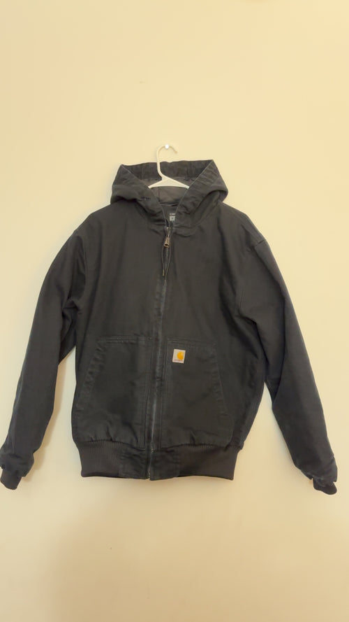 A black Carhartt hooded jacket with a front zipper and a small orange Carhartt logo patch on the chest, 